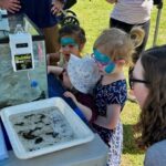 EnviroScience's booth at the 2024 Arbor Day Celebration event in Franklin, TN, captivated young minds through interactive displays with live aquatic organisms, mussel shells, and field equipment.